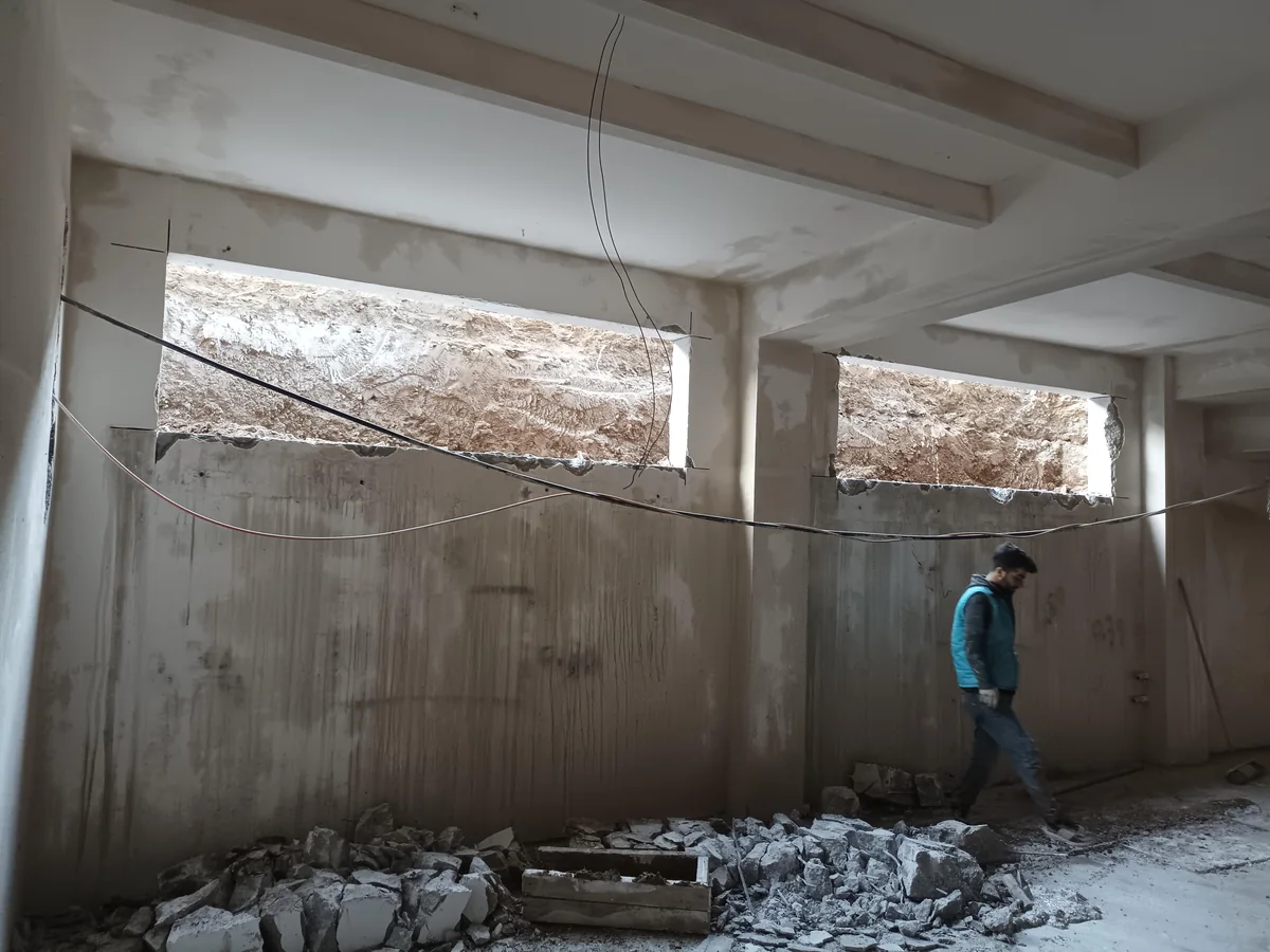 Beton duvarda yatay açıklık ve kesim/söküm izi görünen iç mekân.
