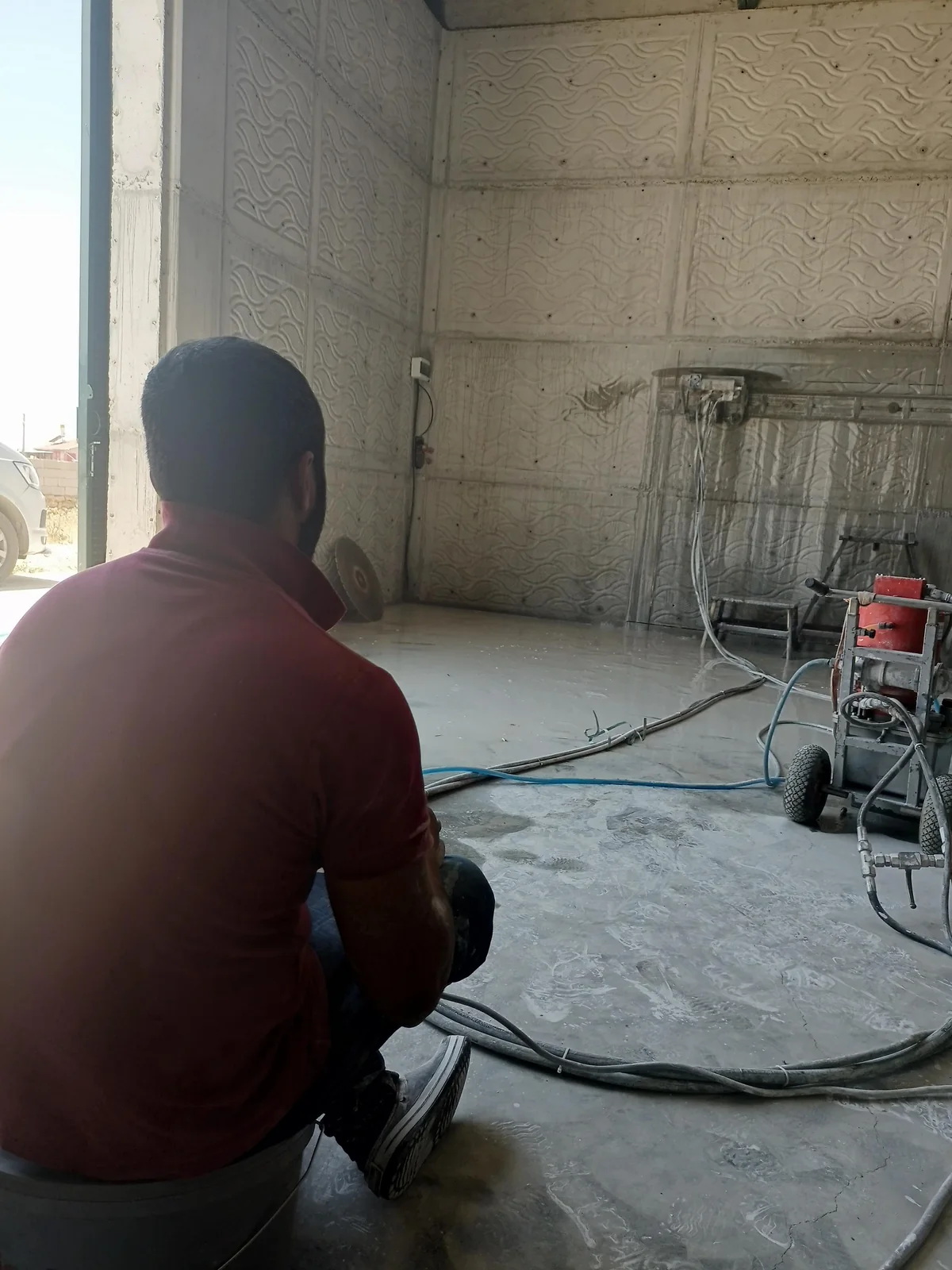 Operatörün beton delme ekipmanı yanında çalıştığı iç mekân.