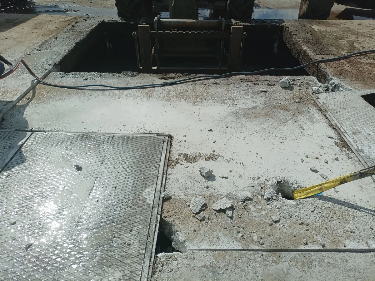 Açılmış beton döşeme kenarlarında kesim izi ve ağır ekipman.