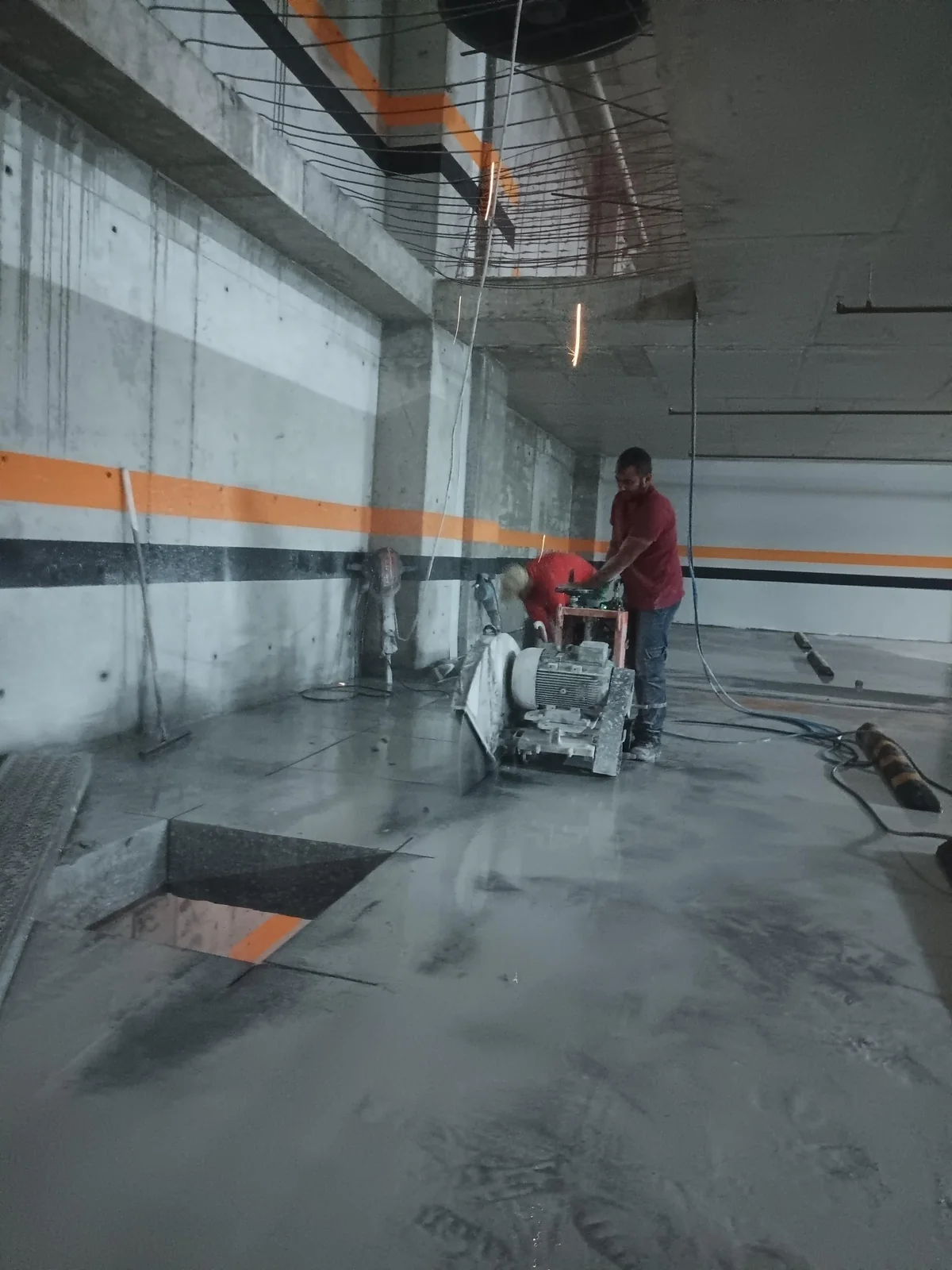 Beton döşemede kesim ekipmanı ve ıslak kesim yüzeyi.